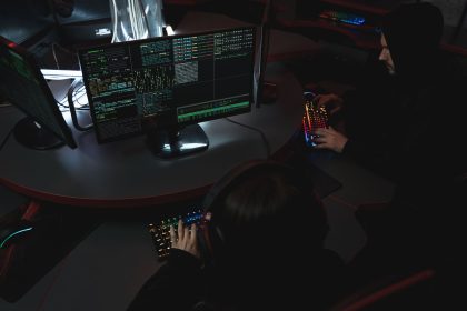 Equipe trabalha diante de computadores em uma sala escura, em atividade relacionada à segurança cibernética.
