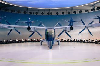 Protótipo de aeronave elétrica futurista com hélices, exibido em ambiente interno.
