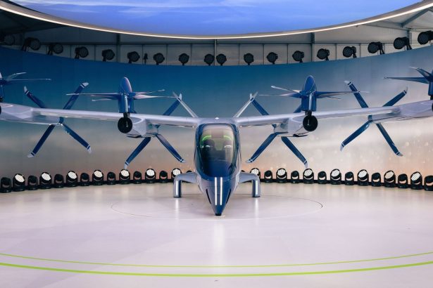 Protótipo de aeronave elétrica futurista com hélices, exibido em ambiente interno.