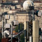 Antenas de telecomunicações instaladas no topo de um edifício, contra o céu.