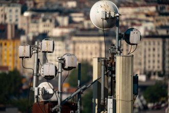 Antenas de telecomunicações instaladas no topo de um edifício, contra o céu.