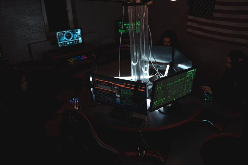 Equipe trabalha diante de computadores em uma sala de monitoramento de segurança digital.