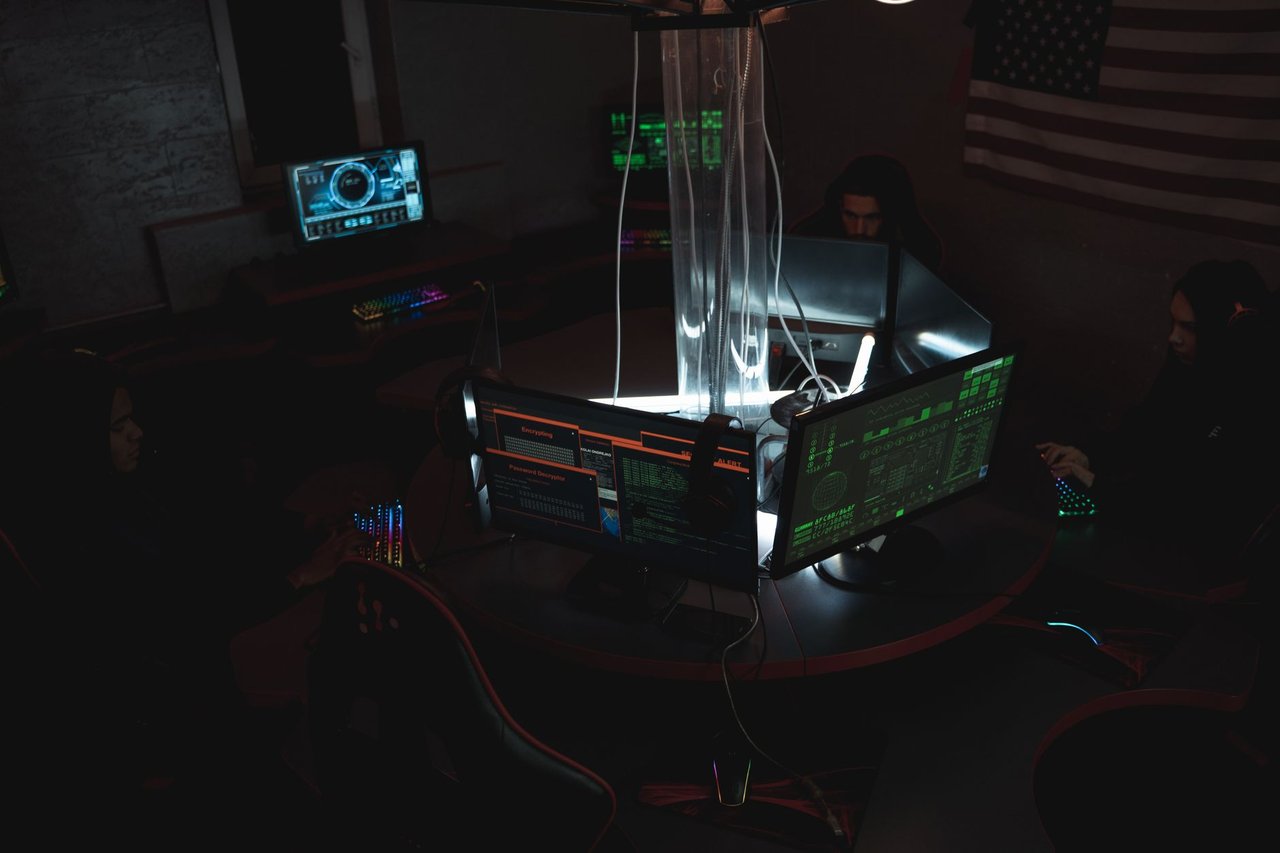 Equipe trabalha diante de computadores em uma sala de monitoramento de segurança digital.