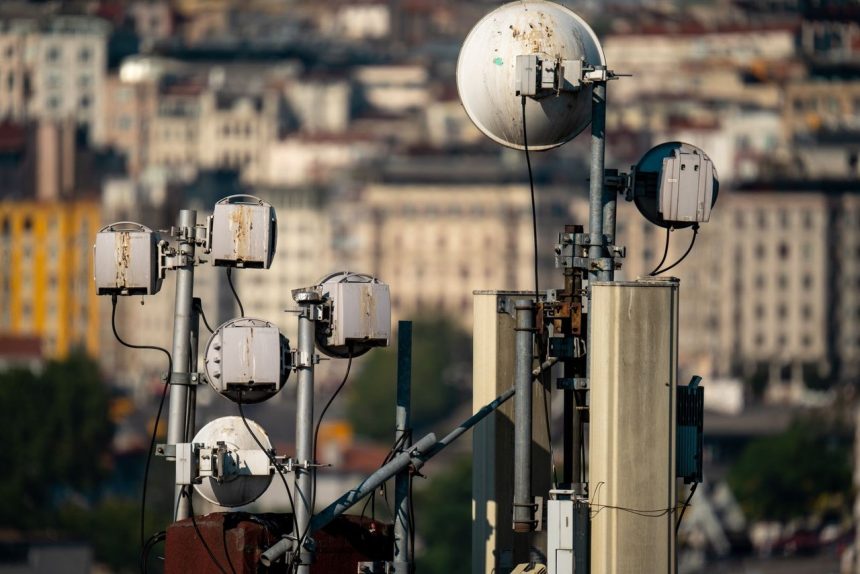 Antenas de telecomunicações instaladas no topo de um edifício, contra o céu.