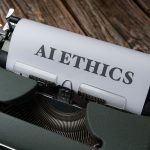 Máquina de escrever com uma folha que traz a expressão “AI Ethics”, em referência à ética no uso da inteligência artificial.
