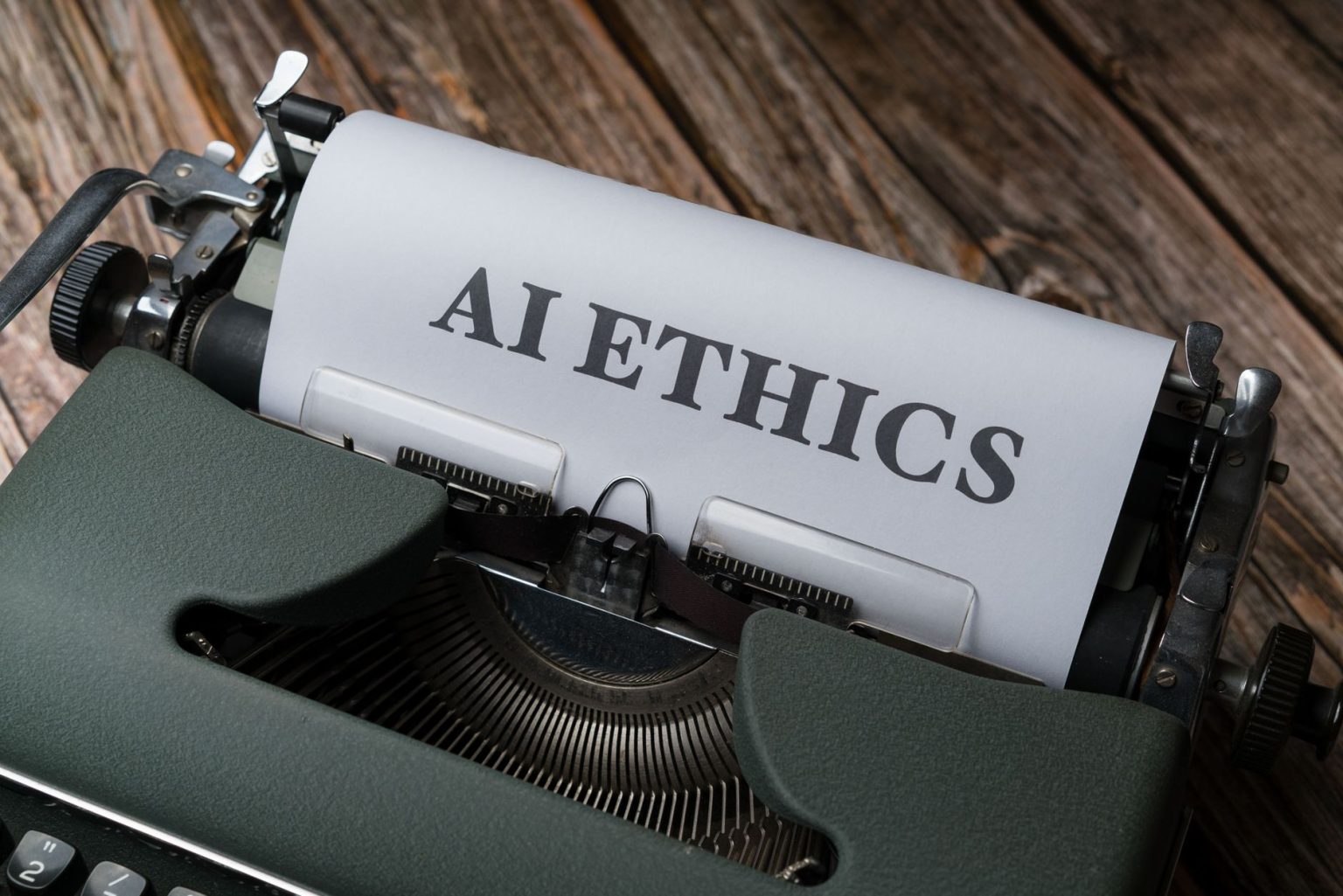 Máquina de escrever com uma folha que traz a expressão “AI Ethics”, em referência à ética no uso da inteligência artificial.