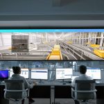 Equipe monitora sistemas digitais e painéis em uma moderna sala de controle.